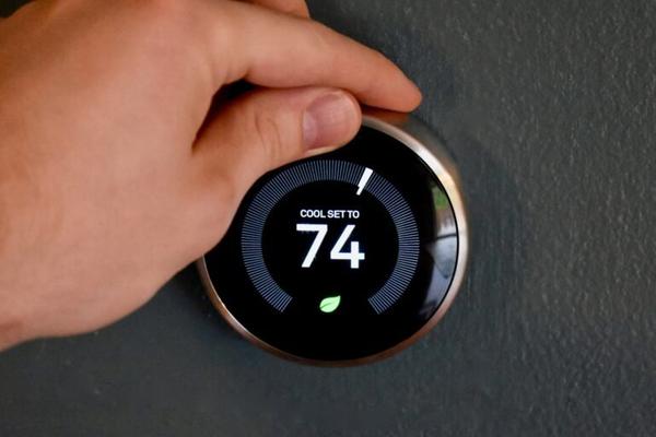 Smart thermostat installation on wall in Dallas Texas home with AC system